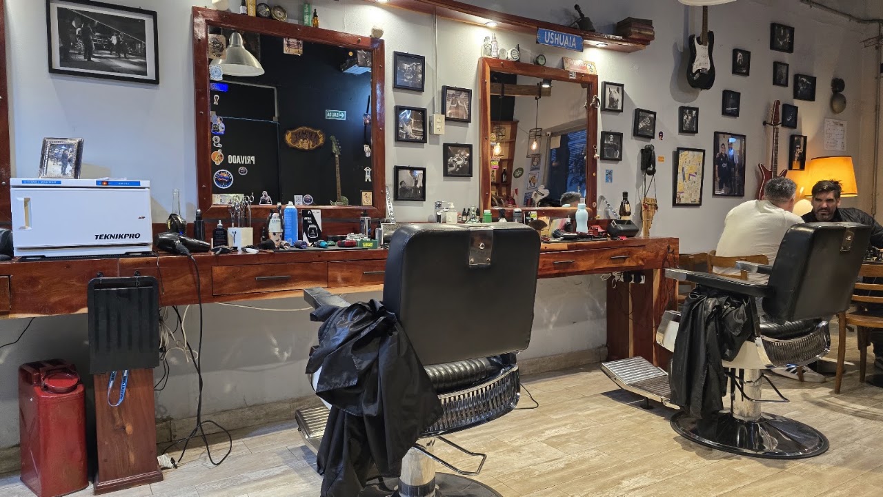 Vista interior de ANIMAL barbería mostrando sillones de cuero vintage y ambiente lounge premium